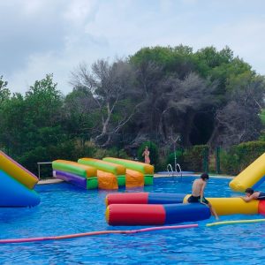 Parque acuático hinchable flotante con tobogán y obstáculos en piscina