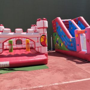 Castillo hinchable medieval con tobogán en pista deportiva